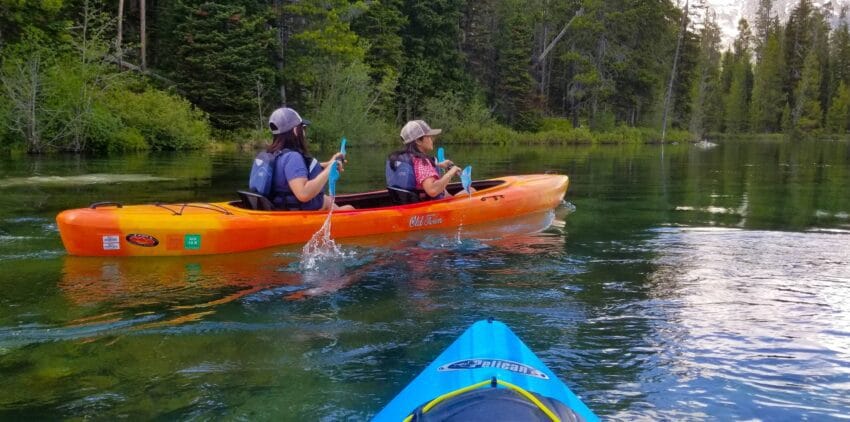 Girls kayaking String Lake, Wyoming. Peruvian woman and Chilean woman.